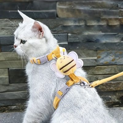 Beige and gray bee plush toy on a yellow harness for cats, adorable pet accessory for cats or small animals.