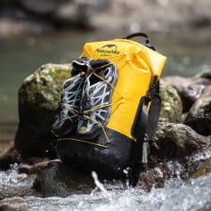 Yellow Naturehike dry bag with hiking shoes attached, suitable for outdoor adventures and water sports; waterproof gear for camping and trekking.