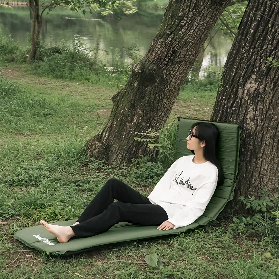 Relaxing woman lying on a green garden lounge near the lake, enjoying nature and outdoor relaxation.