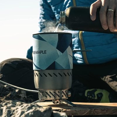 Portable camping stove with integrated windscreen, ideal for outdoor cooking and hiking; compact and lightweight for easy transport.