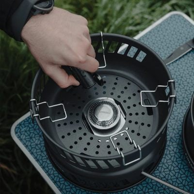 Portable outdoor camping stove with propane canister and ignition system for cooking in nature. Perfect for camping, hiking, and outdoor adventures, providing reliable heat source in the wilderness.