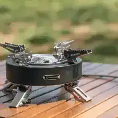 Compact portable camping stove with foldable arms for outdoor cooking and backpacking, ideal for camping, hiking, and outdoor adventures.