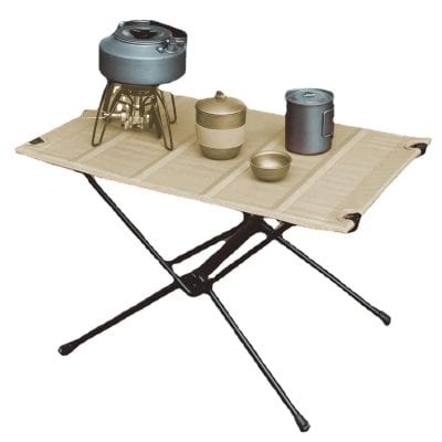 Vintage military mess kit on portable foldable table for outdoor dining, camping, or military use. Durable camping cookware set with mess tins, cups, and utensils for military or outdoor expeditions.