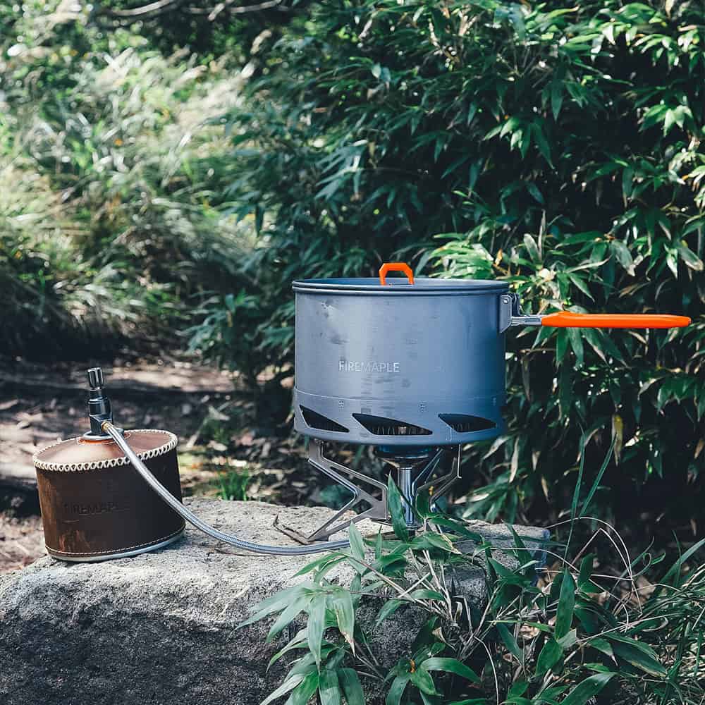 Compact portable camping stove with a fuel canister, perfect for outdoor cooking adventures in nature settings.