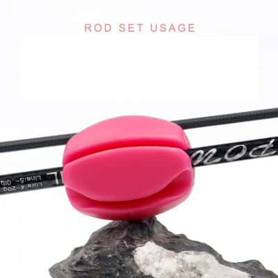 Bright pink rubber fishhook eyelet and fishing rod segment for fishing gear and bait setup, showcased on a rugged rock surface. Perfect for anglers looking for high-quality fishing accessories and equipment.