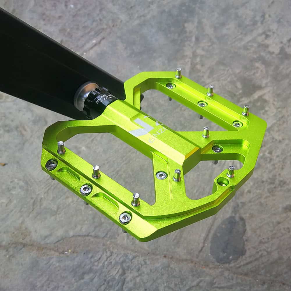 Bright green bicycle pedal with metal studs, lightweight aluminum construction, suitable for mountain and road bikes, durable and high-performance cycling accessory.