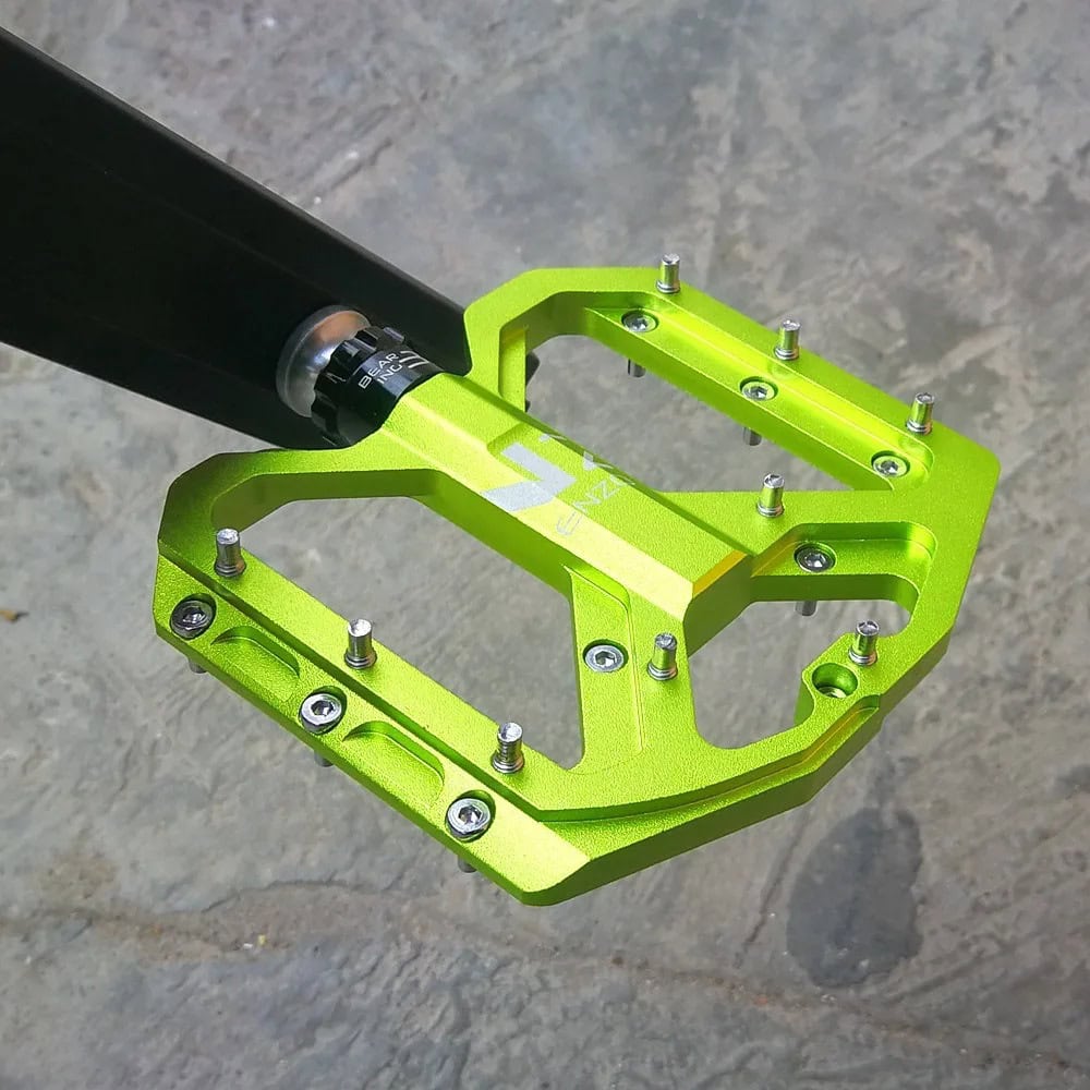 Aluminum mountain bike pedal with vibrant green finish and durable construction, designed for optimal performance and traction in cycling adventures.