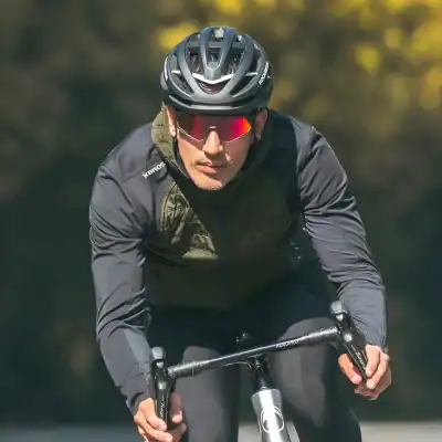 High-performance cyclist wearing a black helmet and sunglasses riding a bicycle outdoors for fitness and sport.