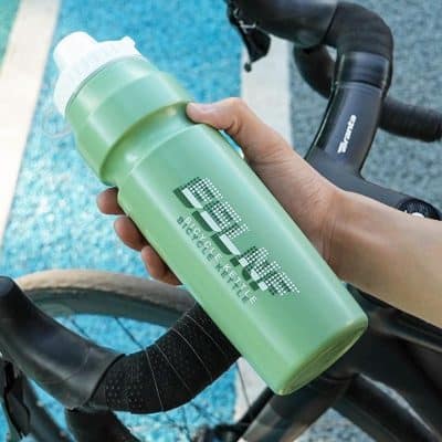 Bicycle water bottle with "Enjoy" logo on a bike handlebar, ideal for cycling enthusiasts.