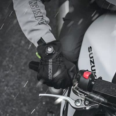 High-quality motorcycle racing glove with RockBibs branding, worn by rider on Suzuki bike, showcasing safety gear for motorcycle enthusiasts and sports riders.