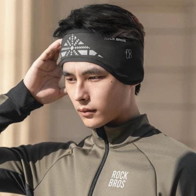 Stylish athletic man wearing a black and gray sports headband and sporty jacket, showcasing activewear from Monalisa Store for fitness and outdoor activities.