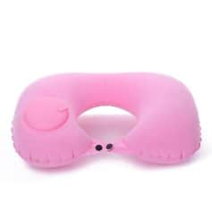 Pink inflatable travel pillow with built-in eye mask for comfort on flights and travel.