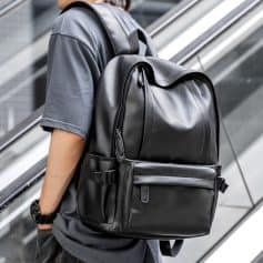Black leather backpack for travel and business, featuring multiple compartments and adjustable straps, ideal for professionals and students on the go.