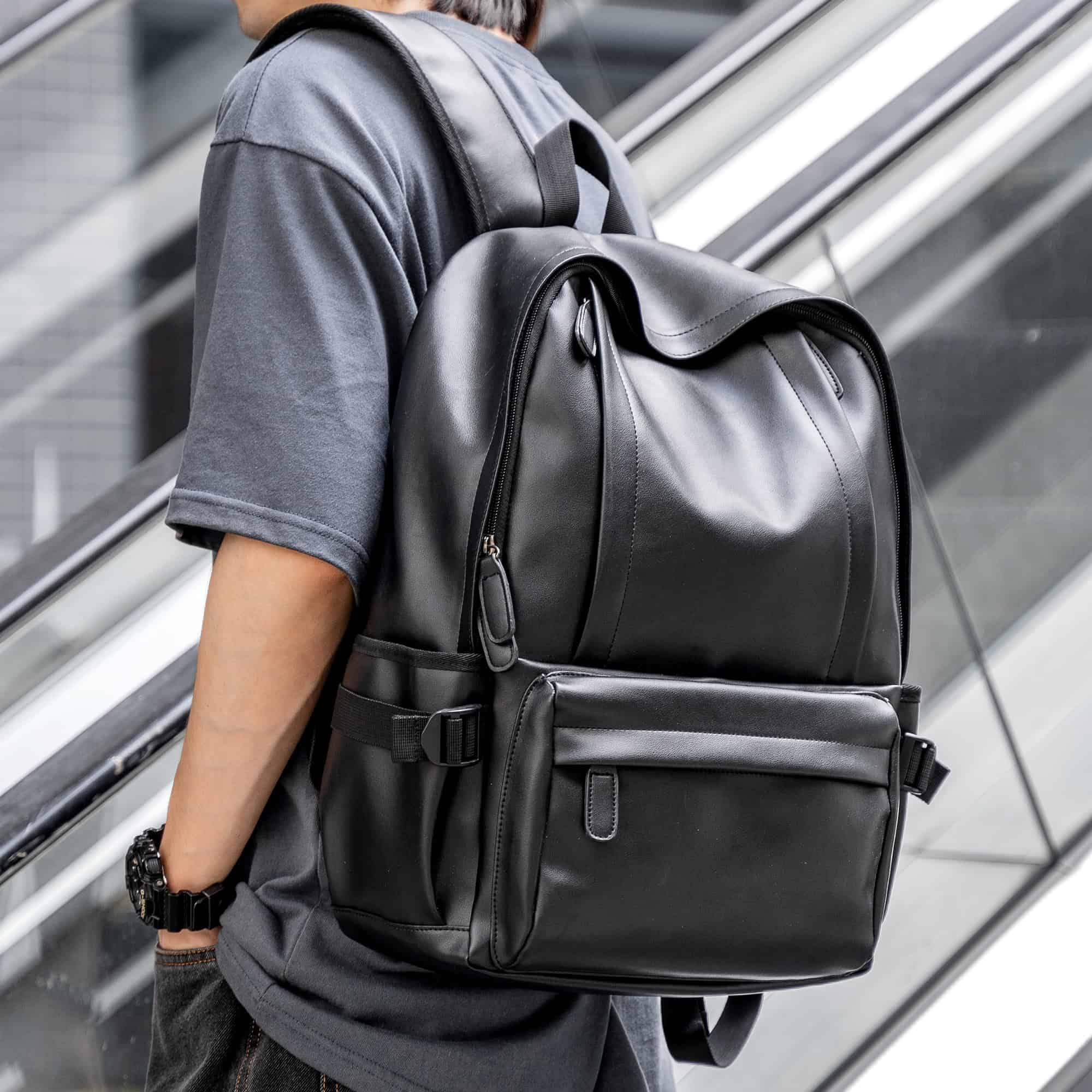 Black leather backpack for travel and business, featuring multiple compartments and adjustable straps, ideal for professionals and students on the go.