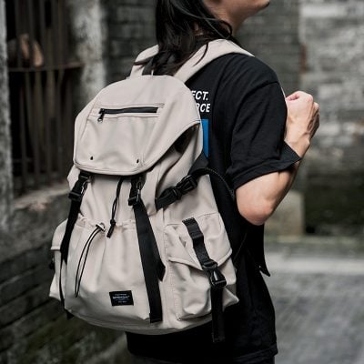 Versatile beige backpack with multiple compartments, perfect for travel and daily use, featuring adjustable straps and durable material for comfort and convenience.