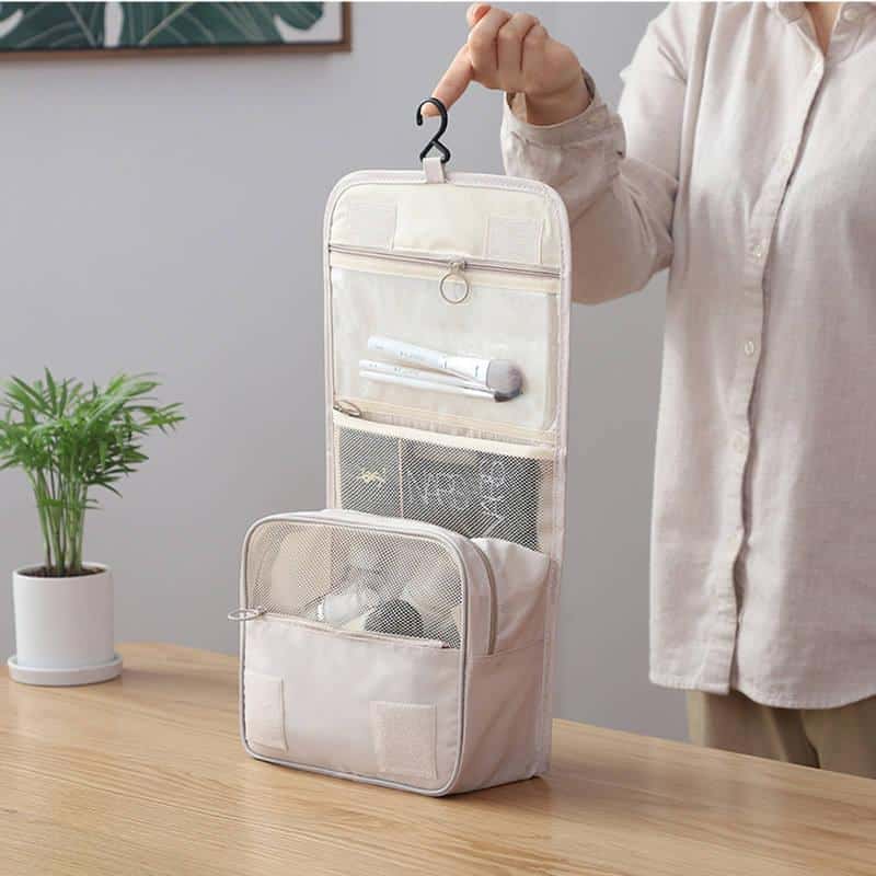 Portable hanging toiletry bag for travel storage, ideal for cosmetics, toiletries, and accessories, featuring multiple compartments and mesh pockets.