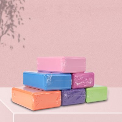 Face tissues in pastel colors stacked on a pink surface against a pink background with shadowed foliage, suitable for optometry or eye care products.