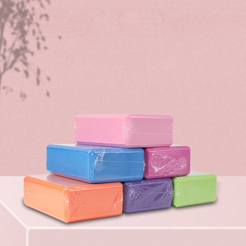 Face tissues in pastel colors stacked on a pink surface against a pink background with shadowed foliage, suitable for optometry or eye care products.