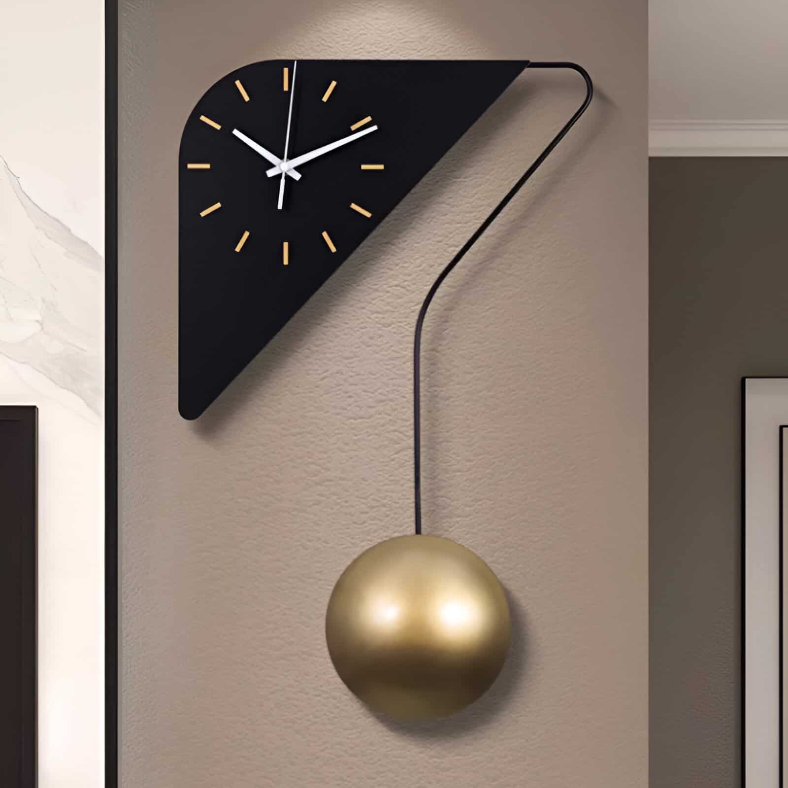 Stylish modern wall clock with a black triangular face, gold hour markers, and a swinging pendulum in a gold spherical body, perfect for contemporary home decor.