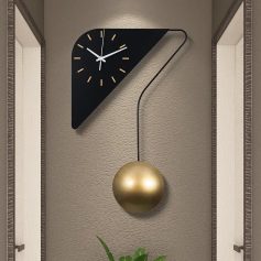 Contemporary modern wall clock with a sleek black triangular design and gold pendulum, perfect for stylish home or office decor.