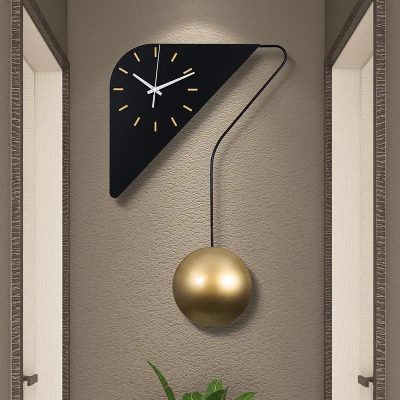 Contemporary modern wall clock with a sleek black triangular design and gold pendulum, perfect for stylish home or office decor.