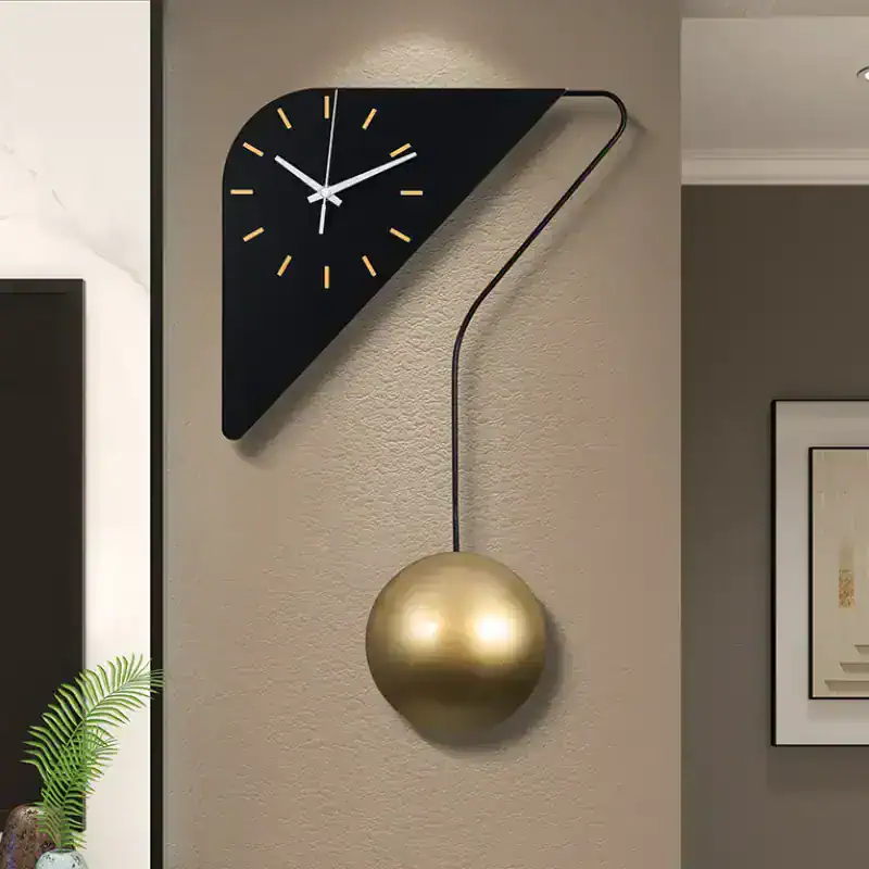 Modern wall clock with a black geometric triangle design and a gold pendulum, stylish home decor piece.