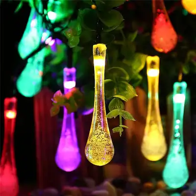 Vibrant LED string lights shaped like colorful test tubes hanging among green plants for a lively, decorative look. Perfect for gardens, patios, and indoor party ambiance.