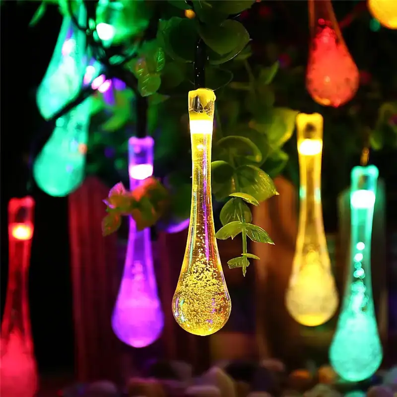 Vibrant LED string lights shaped like colorful test tubes hanging among green plants for a lively, decorative look. Perfect for gardens, patios, and indoor party ambiance.