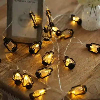Miniature amber glass bottle string lights for cozy home decor - perfect for ambient lighting and visual appeal.