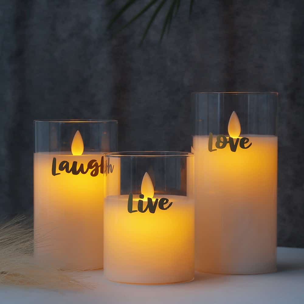 Soft candlelight with engraved words "Laugh," "Live," and "Love" creates a warm, inviting ambiance, ideal for home decor and special occasions. Perfect for enhancing your living space with elegant, motivational decorative candles.