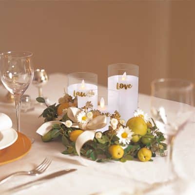 Elegant wedding table centerpiece with candles, fresh flowers, and green apples, perfect for romantic celebrations and special occasions.
