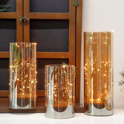 Metropolitan decorative LED candle lights, modern metallic candle holders, elegant indoor lighting decor, stylish reflective candle containers, advanced LED lighting for home decor.