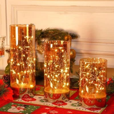 Warm golden LED string lights inside tall glass cylinders, for festive holiday decor and Christmas ambiance, Monalisa Store opt.