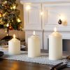 Large white flameless LED candles for home holiday decor, ideal for Christmas and winter decorations, creating a cozy festive atmosphere.