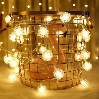 Wire basket with warm LED fairy lights and a pink flamingo decoration, creating a cozy and decorative ambiance perfect for home decor or special events.