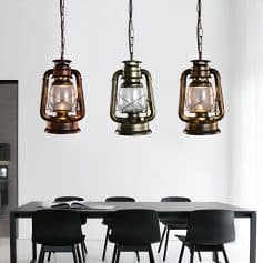 Vintage-style oil lantern pendant lights hanging over a modern dining table in a stylish interior, adding rustic charm and warm lighting to the Monalisa Store.