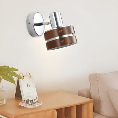 Modern wall-mounted adjustable spotlight with leather accents suitable for stylish interior lighting.