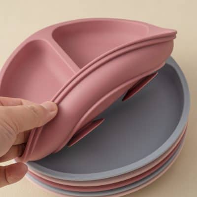 Stacked baby blue and pink silicone feeding bowls with divided sections, minimalist design, high-quality materials for baby care, from Monalisa Store.