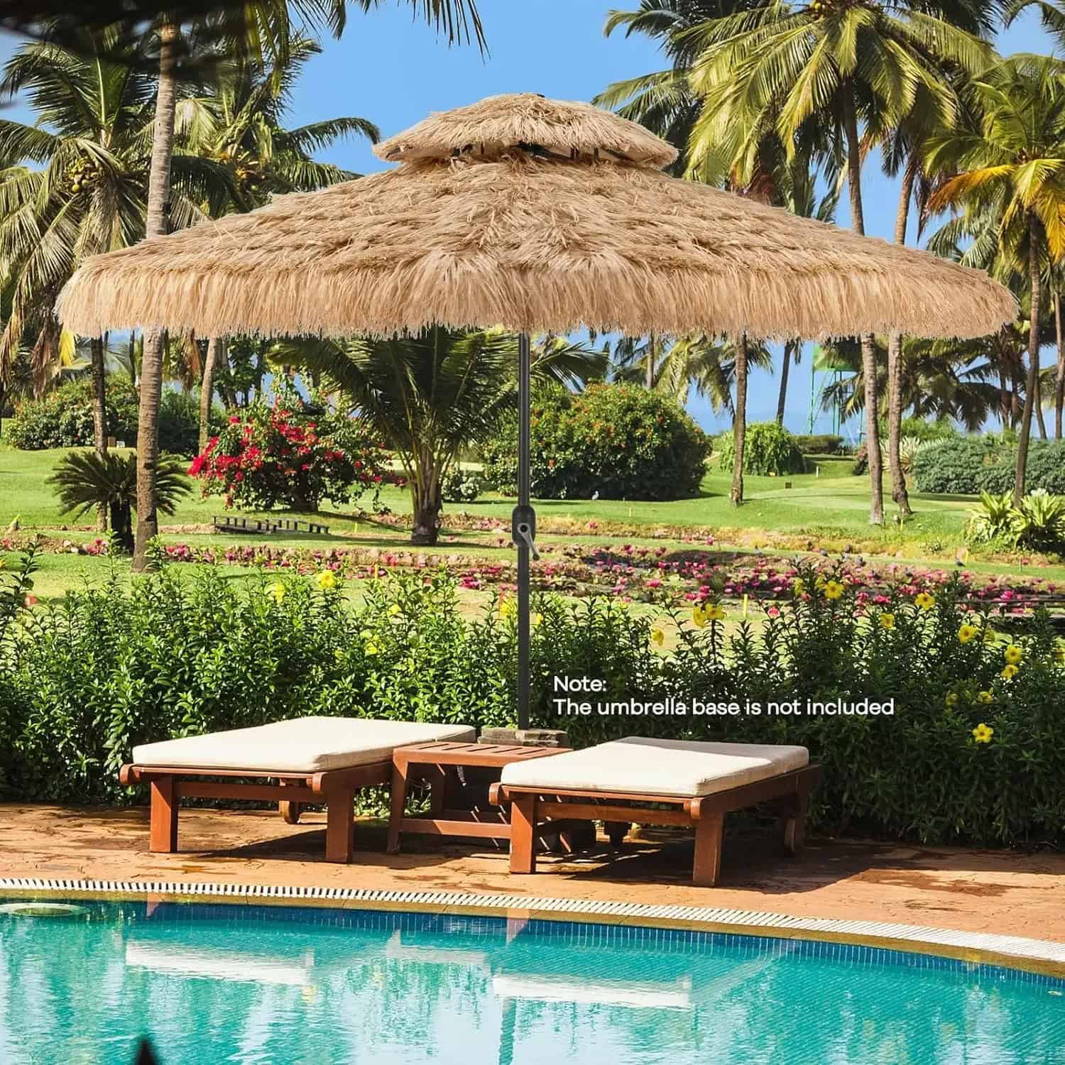 Beachside poolside scene featuring a large straw umbrella with wooden lounge chairs beneath, surrounded by lush tropical greenery, vibrant flowers, and tall palm trees, creating a relaxing vacation atmosphere.
