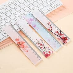 Delicate floral-themed transparent rulers placed on a pastel-colored desk beside a white keyboard, perfect for precise measurement in beauty, fashion, or stationery projects.