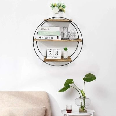 Decorative wall shelf with optical fashion books and a vintage hourglass in a stylish optometry setting.