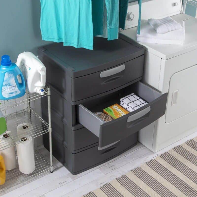 Laundry room with black and white washing machines, detergent bottles, and storage drawers for opt textiles and clothing maintenance.