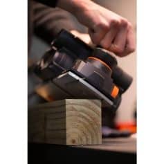 Close-up of a cordless power sander polishing a wooden surface for smooth finish.