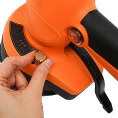 Close-up of a finger adjusting the settings on an orange medical laser device used for eye treatments and vision correction procedures.