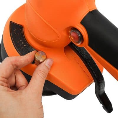 Close-up of a finger adjusting the settings on an orange medical laser device used for eye treatments and vision correction procedures.
