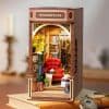 Miniature bookstore storefront with shelves of books, a cozy red armchair, and detailed decor, perfect for book lovers and hobby enthusiasts. A charming display of literary decor for home or office.