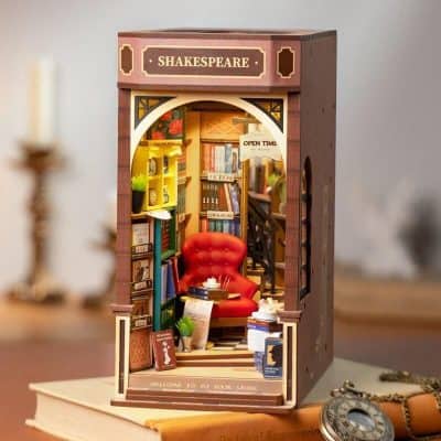 Miniature bookstore storefront with shelves of books, a cozy red armchair, and detailed decor, perfect for book lovers and hobby enthusiasts. A charming display of literary decor for home or office.