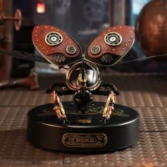 Intricate robotic butterfly with steampunk design featuring leather wings and metallic gears, sitting on a decorative base. Perfect for modern decor or tech-inspired art displays.