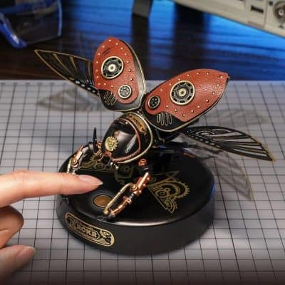 Detailed steampunk-style robotic butterfly with intricate copper and black design, wings with gears, perfect for decor or collectors seeking unique steampunk art pieces.