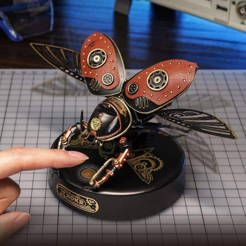 Detailed steampunk-style robotic butterfly with intricate copper and black design, wings with gears, perfect for decor or collectors seeking unique steampunk art pieces.